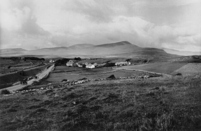 Rural village with road, stone walls, rolling hills